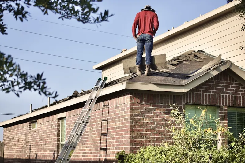 Professional roofer working on a residential roof in DeWitt